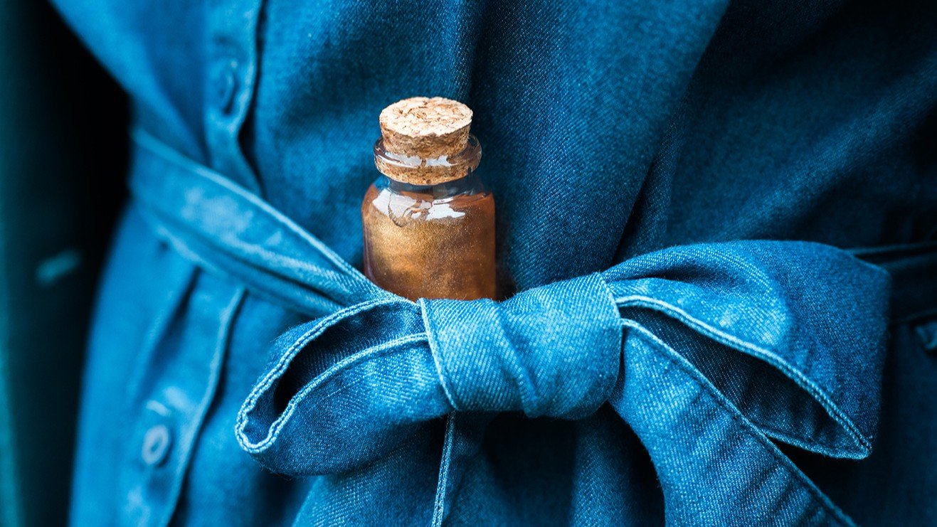 robe en jean. fiole de potion contenant un liquide doré brillant.